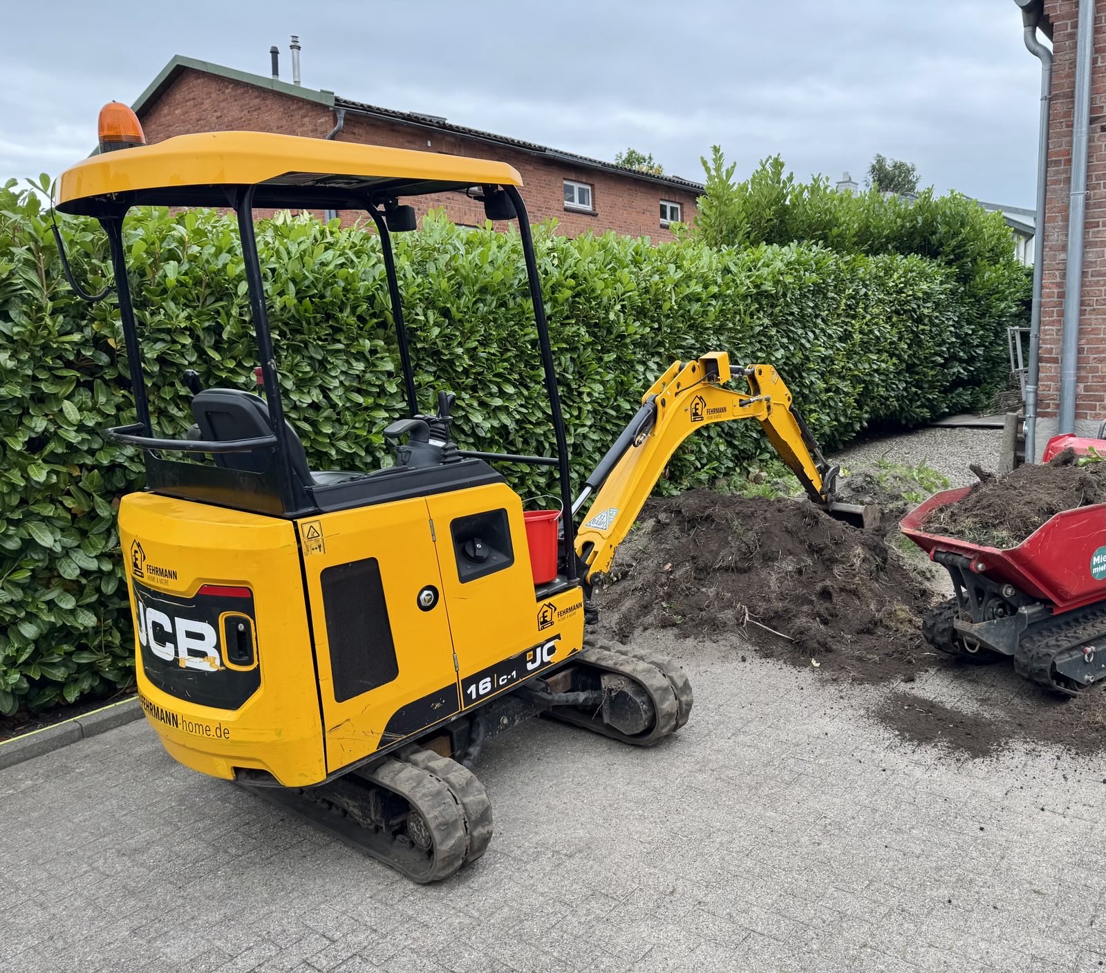 JCB 16C-1 beim Materialtransport und Grundstückspflege